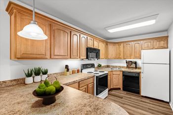 A kitchen with wooden cabinets and a granite countertop.